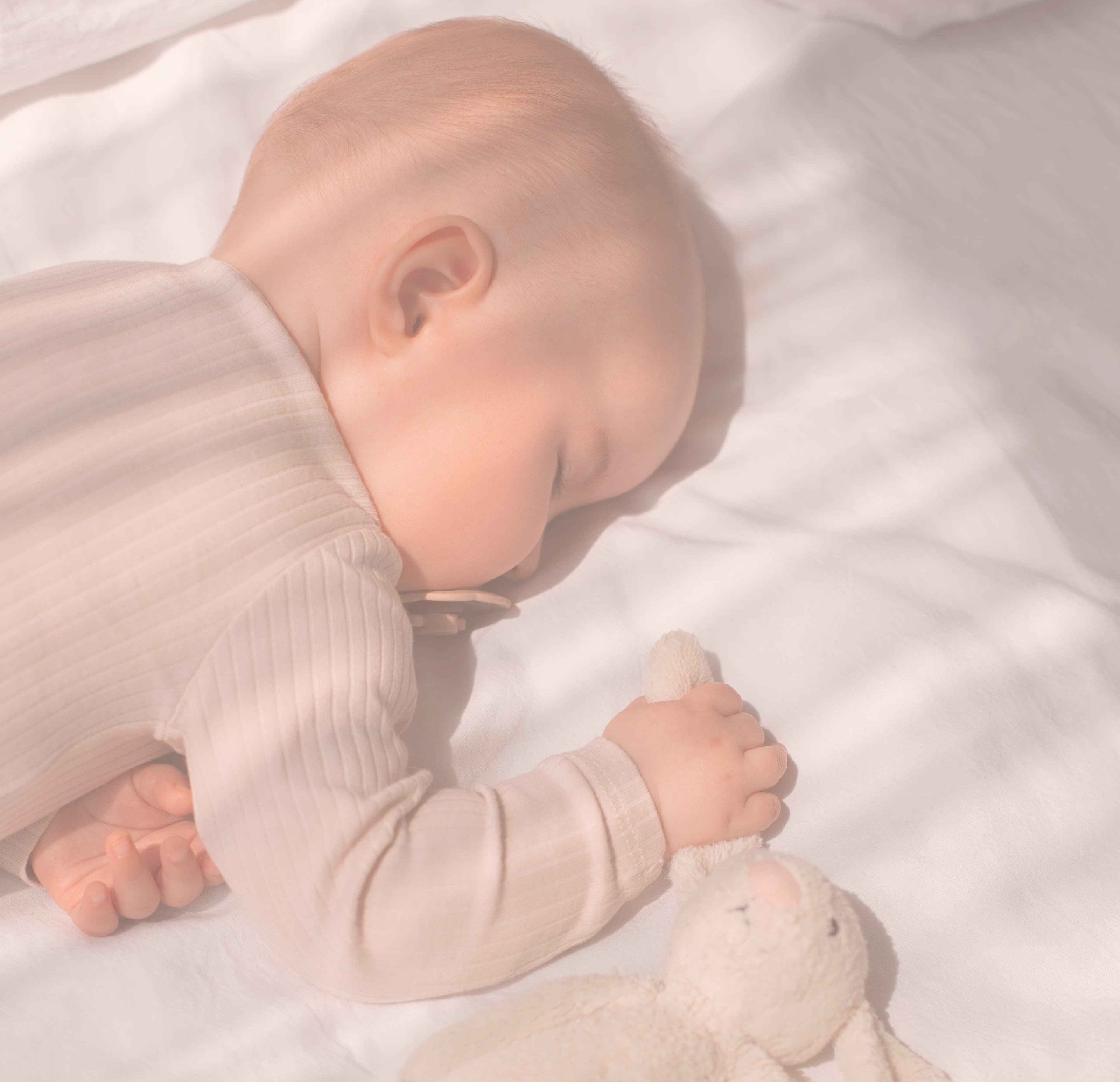 Peacefully sleeping newborn, ready to be welcomed with gifts from a Kikinous baby registry